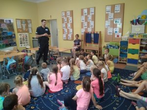 Policjant do spraw profilaktyki z Komisariatu Policji w Chełmży na spotkaniu z dziećmi w Brąchnowie