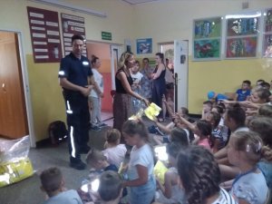 Policjant do spraw profilaktyki z Komisariatu Policji w Chełmży na spotkaniu z dziećmi w szkole w Ostaszewie