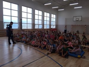 Policjant do spraw profilaktyki z Komisariatu Policji w Chełmży na spotkaniu z dziećmi w szkole w Pigży