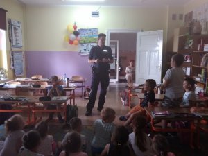 Policjant do spraw profilaktyki z Komisariatu Policji w Chełmży na spotkaniu z dziećmi w szkole w Sławkowie