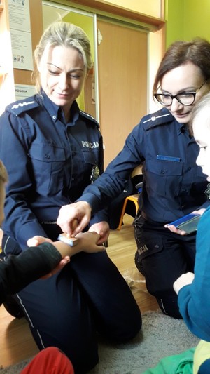 Policjantki wykonują pieczątki na rączkach dzieci