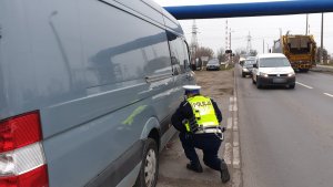 policjant sprawdza spaliny w samochodzie dostawczym