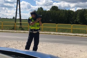 radiowóz i policjant z miernikiem prędkości