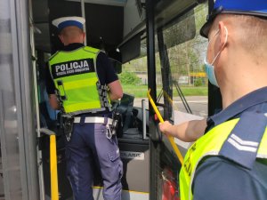 dwóch umundurowanych policjantów w kabinie autobusu mzk