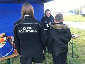 Policjanta wraz z uczennicami klasy o profilu policyjnym z II Liceum Ogólnokształcącego w Toruniu rozmawia z uczestnikami &quot;Święconki w kasku&quot;
