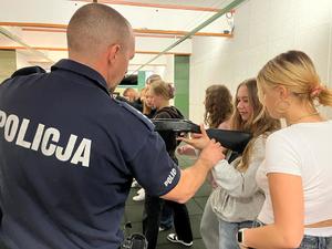 Policjant pokazuje uczniom, jak obchodzić się z bronią